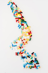 top view of arrow made of medical pills on white