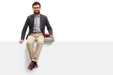 Young teacher sitting on panel and looking at the camera