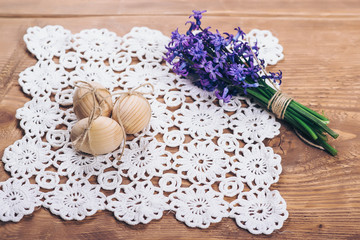 Three wooden easter eggs and spring flowers.