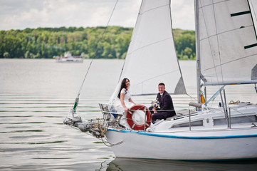 Fototapeta premium Wedding couple in love at small sailboat yacht on lake.