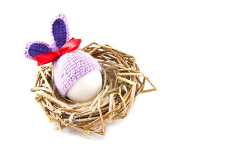 Easter eggs in the nest. Knitted Easter Bunny. Egg in Easter bunny cap.