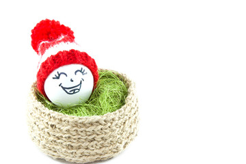 Easter eggs in a basket. Emoticons in knitted hats with pom-poms. Knitted basket of jute, sisal green. Handmade.