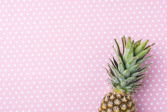 Fresh pineapple on pink dotted background