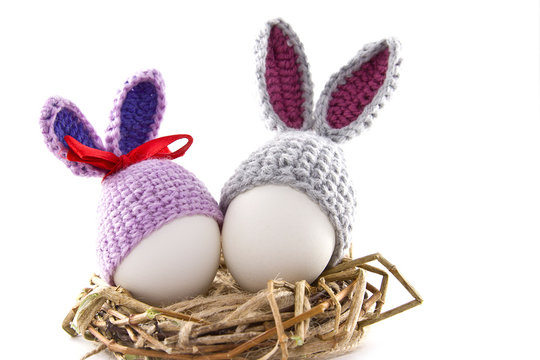 Easter eggs in the nest. Knitted Easter Bunny. Egg in Easter bunny cap.