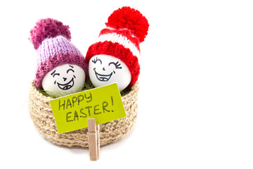 Easter eggs in a basket. Emoticons in knitted hats with pom-poms. Knitted basket of jute, sisal green. Handmade.