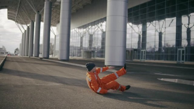 Construction worker in uniform doing difficult somersault and falling down. Parkour unsuccessful