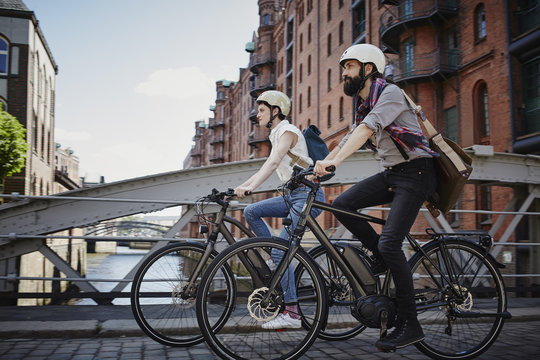 Man and woman riding bikes in city