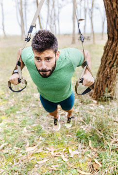 Man doing suspension training outdoors