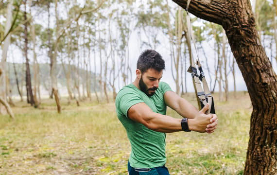 Man doing suspension training outdoors