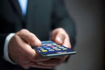 Hand holding black smartphone with operating system screen