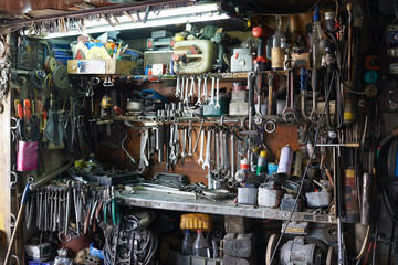Shelves filled with different arranged wrenches, mechanic tools and other equipment in workshop garage