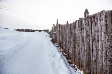 An old, wooden fence in the winter scenery