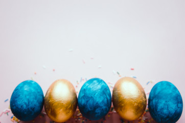 colorful blue and golden easter eggs with confectionery sprinkling