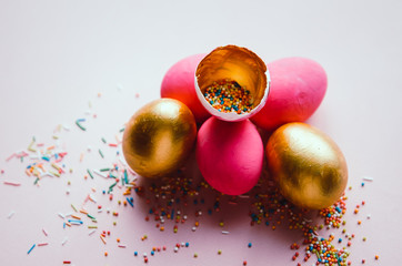 colorful pink and golden easter eggs with confectionery sprinkling