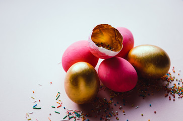 colorful pink and golden easter eggs with confectionery sprinkling