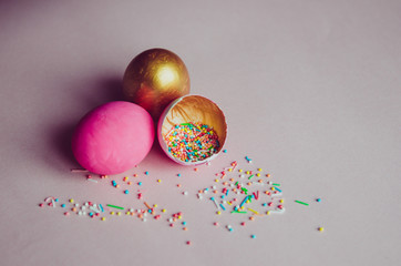 colorful pink and golden easter eggs with confectionery sprinkling