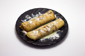 Delicious hot pancakes on a black plate isolated on a white background
