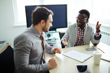 Two male financial managers in checked shirts sitting in modern office and preparing annual accounting reports