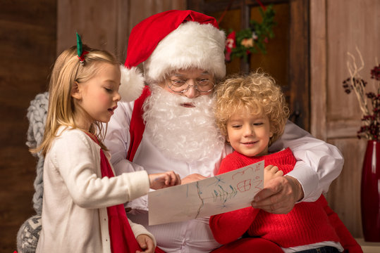 Children showing picture to Santa Claus