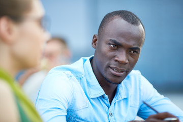 Obraz premium Portrait of handsome African business man busy having discussion with people out of frame