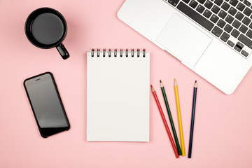 Home office stuff with laptop, notebook, cup of coffee and other supplies