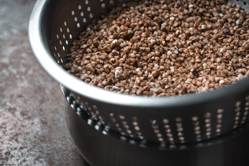 Buckwheat in the metal  colander horizontal