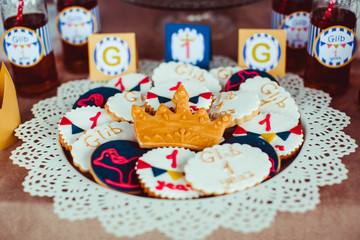 Cookies with colorful glaze and crown served on plate