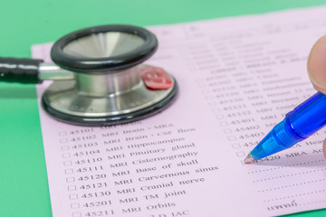 hand doctor hold a pen write select choice odrer sheet and stethoscope on the sheet