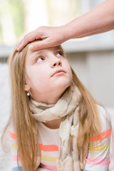 mother touches the forehead of the child, checking the temperature