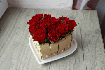 Cœur en roses rouge sur assiette en porcelaine blanche forme romantique