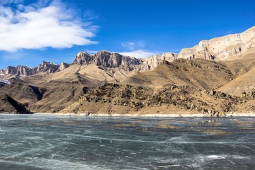 замерзшее озеро в горном ущелье, весна, горные склоны, природа Северного Кавказа, красивый пейзаж