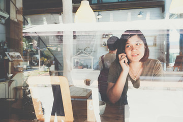 Woman drinking coffee in vintage cafe and talking cellphone