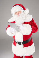 Fototapeta na wymiar Santa Claus listening music with headphones