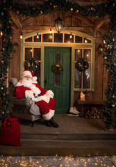 Happy Santa Claus sitting in armchair
