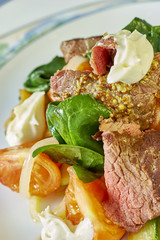 meat salad with green tomatoes on the plate blue background lot of food recipes