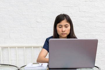 young asian woman internet on mobile phone during rest in coffee shop