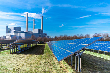 Solaranlage unter Sonnenstrahlen neben einem Heizkraftwerk