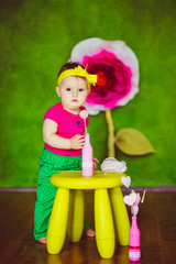 Worried kid stands before little yellow chair with pink bottle on seat