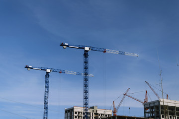 Crane and building under construction against blue sky