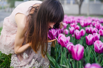 gentle woman sniffing tulips