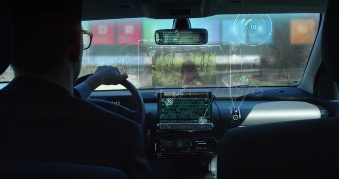 A man driving a technological and futuristic machine in which holograms appear for a driver assistance and video calls. Concept of machines of the future, driving safety, technology and transport