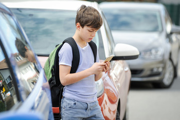 Kind spielt  mit seinem Handy im Straßenverkehr und begibt sich in Gefahr