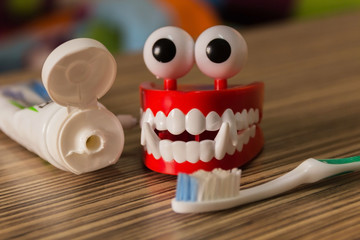 Set of complete denture;frontal view of upper and lower removable prosthesis and the grey toothbrush with toothpaste to clean