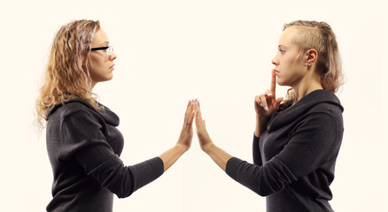 Self talk concept. Young woman talking to herself, showing gestures. Double portrait from two different side views.