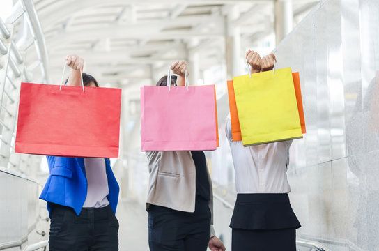 Group of shopping asia women holding up shopping bags.