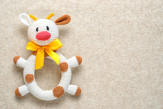 amigurumi toy cow on a knitted background with copy space