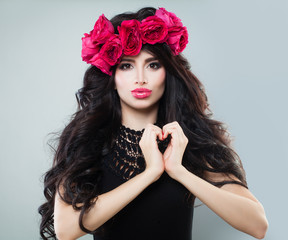 Naklejka premium Perfect Woman with Long Healthy Hairstyle, Makeup, Heart and Rose Flowers. Studio Portrait