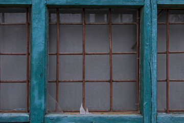 Fototapeta na wymiar Old broken window with rusty iron lattices