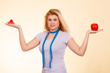 Woman with measuring tape choosing what to eat