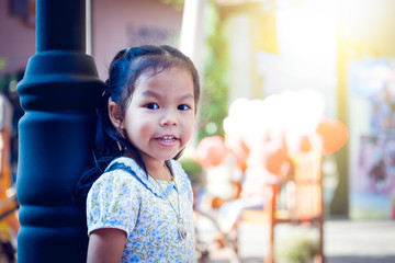 Asian little girl standing and looking in park